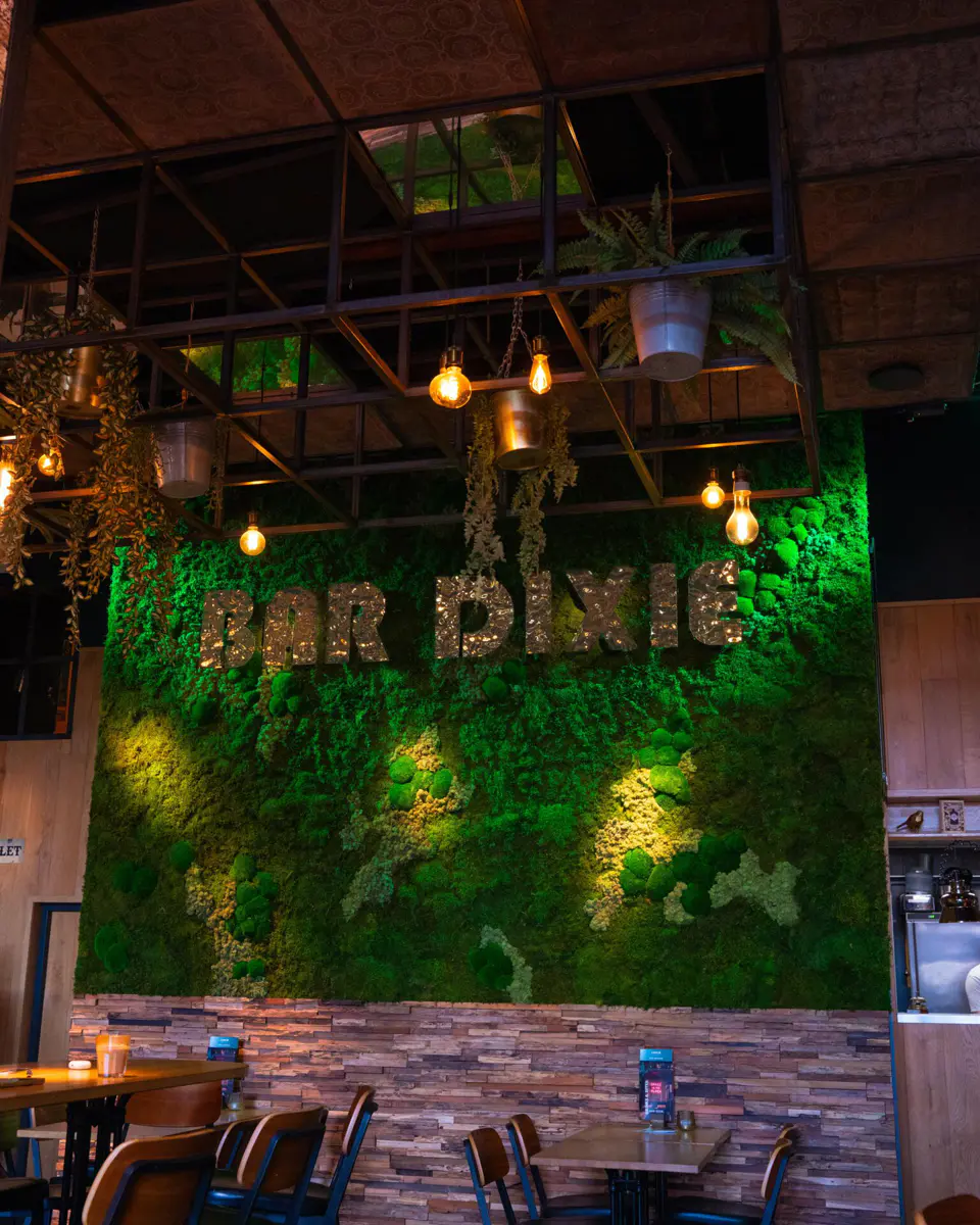 Moswand met logo van Bar Dixie in Amstelveen restaurant Moswand met groen en Bar Dixie logo
